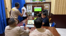 Jajaran personel Polsek Buay Madang Timur bersama masyarakat pencinta sepak bola menyaksikan pertandingan laga Norwegia melawan Perancis saat nonton bareng Pesta Bola Dunia 2026 di Mako Polsek Buay Madang Timur, OKU Timur. 
