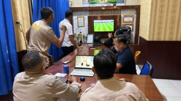 Jajaran personel Polsek Buay Madang Timur bersama masyarakat pencinta sepak bola menyaksikan pertandingan laga Norwegia melawan Perancis saat nonton bareng Pesta Bola Dunia 2026 di Mako Polsek Buay Madang Timur, OKU Timur. 