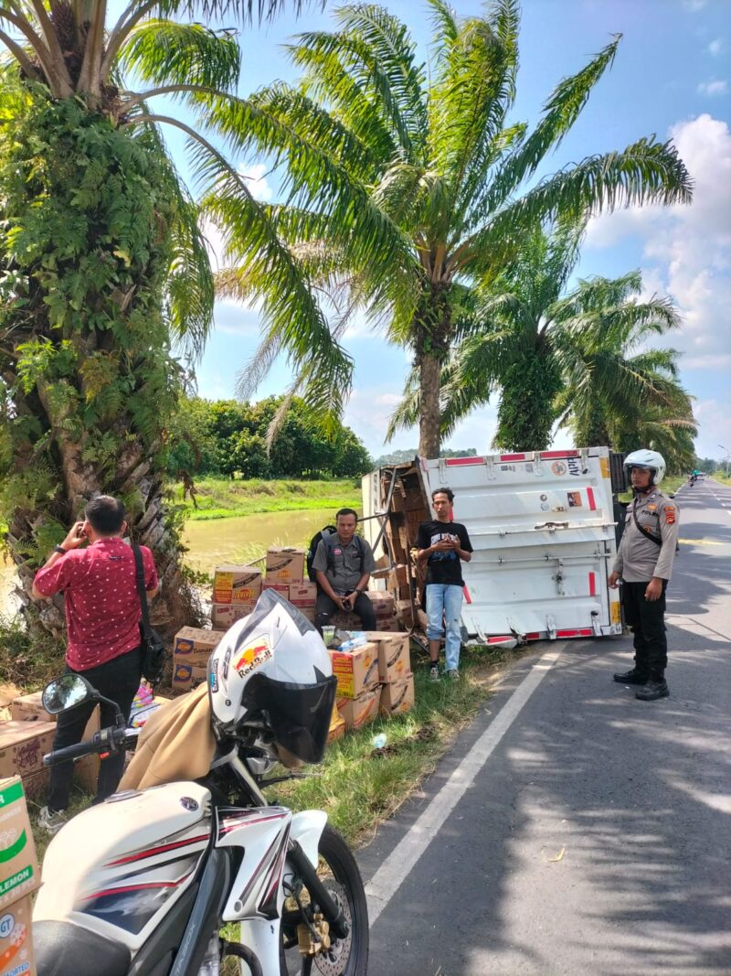 Anggota Polsek Buay Madang Timur berjaga di samping truk box Hino yang terguling di Jalan Raya Lintas Belitang BK 2, Desa Srikaton, Kecamatan Buay Madang Timur, OKU Timur. 