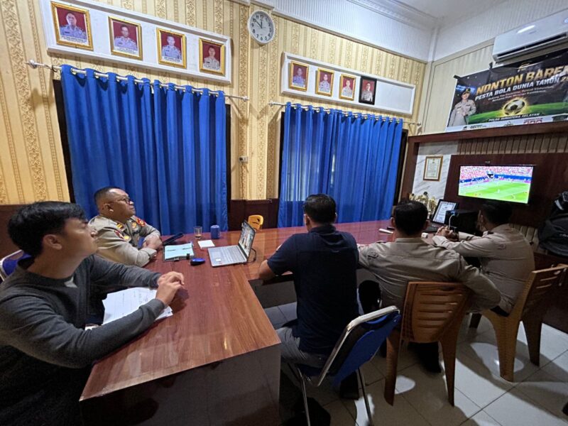 Kapolsek Buay Madang Timur Iptu Swisspo, bersama jajaran anggota dan warga menyaksikan pertandingan babak 32 besar Pesta Bola Dunia 2026 antara Afrika Selatan melawan Kanada di Mako Polsek Buay Madang Timur, Kabupaten OKU Timur. 
