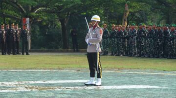 Perwira upacara berdiri tegap di depan barisan peleton TNI dan Polri saat berlangsungnya Upacara Peringatan Hari Bhayangkara ke-80 di Lapangan Pemkab OKU Timur.