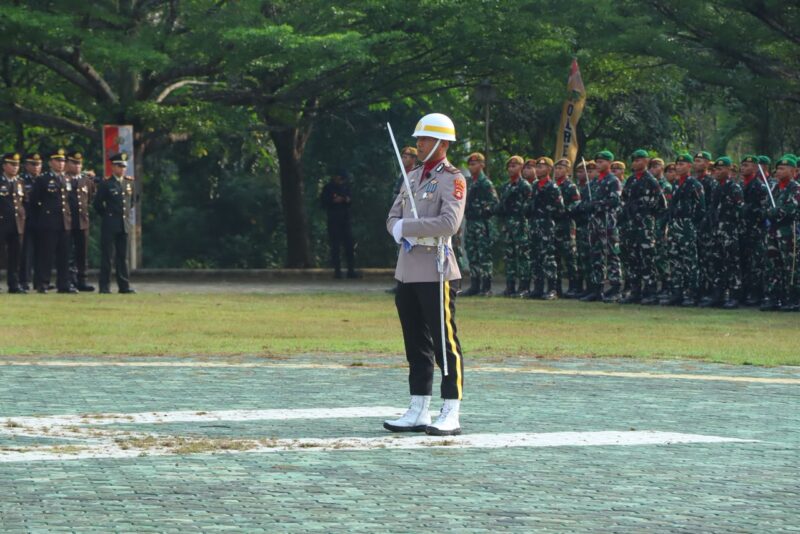 Perwira upacara berdiri tegap di depan barisan peleton TNI dan Polri saat berlangsungnya Upacara Peringatan Hari Bhayangkara ke-80 di Lapangan Pemkab OKU Timur. 