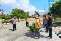 Kapolsek Buay Madang Timur, Iptu Swisspo (kiri), memberikan pengarahan kepada personel dan perwakilan warga saat memulai kegiatan penanaman bibit pohon di area Aspol Mapolsek Buay Madang Timur, Kabupaten OKU Timur. 