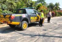 Personel Polsek Buay Madang Timur berjaga di samping kendaraan dinas patroli saat melaksanakan Kegiatan Rutin Yang Ditingkatkan (KRYD) di kawasan Jalan Desa Banyumas Asri, Kecamatan Buay Madang Timur, Kabupaten OKU Timur. 