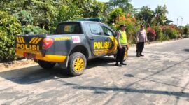 Personel Polsek Buay Madang Timur berjaga di samping kendaraan dinas patroli saat melaksanakan Kegiatan Rutin Yang Ditingkatkan (KRYD) di kawasan Jalan Desa Banyumas Asri, Kecamatan Buay Madang Timur, Kabupaten OKU Timur. 