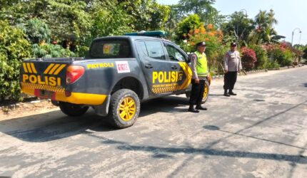 Personel Polsek Buay Madang Timur berjaga di samping kendaraan dinas patroli saat melaksanakan Kegiatan Rutin Yang Ditingkatkan (KRYD) di kawasan Jalan Desa Banyumas Asri, Kecamatan Buay Madang Timur, Kabupaten OKU Timur.