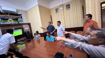 Kapolsek Buay Madang Timur IPTU Swisspo, bersama personel Polsek dan warga sekitar menyaksikan siaran langsung pertandingan Pesta Bola Dunia 2026 antara Spanyol vs Austria di Mako Polsek Buay Madang Timur, Kabupaten OKU Timur, Sumatra Selatan. 
