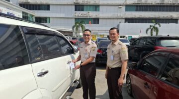 Kepala Bapenda Sumsel, Achmad Rizwan usai memasang hang tag di kendaraan sebagai penginat untuk membayar pajak. Foto: istimewa