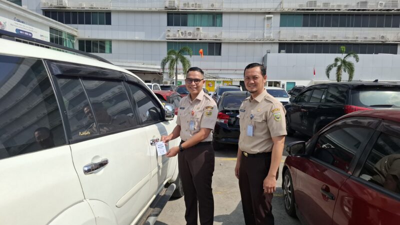 Kepala Bapenda Sumsel, Achmad Rizwan usai memasang hang tag di kendaraan sebagai penginat untuk membayar pajak. Foto: istimewa