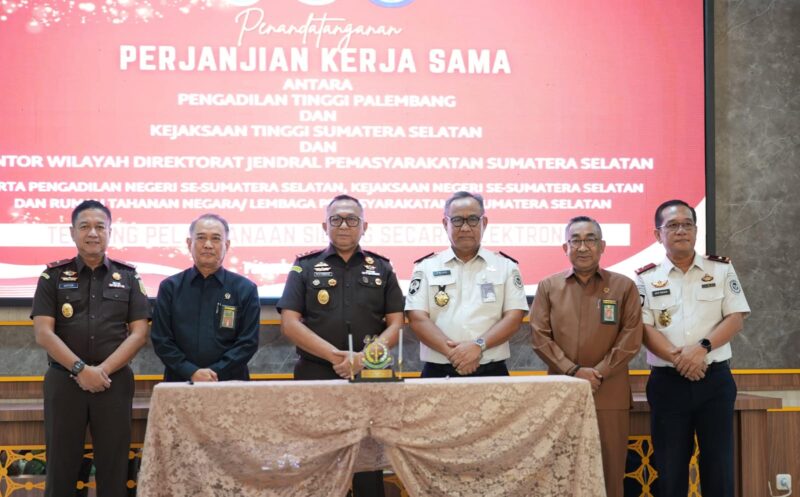 Kepala Kejati Sumsel, Ketua Pengadilan Tinggi Palembang, dan Kepala Kanwil Ditjenpas Sumsel bersama jajaran menandatangani Perjanjian Kerja Sama pelaksanaan persidangan secara elektronik di Aula Lantai 9 Kejati Sumsel, Selasa (7/7/2026).
