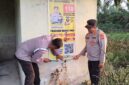 Kapolsek Buay Madang Timur, Iptu Swisspo, mendampingi anggotanya memasang spanduk sosialisasi layanan kepolisian dan larangan membakar hutan di Desa Teko Rejo, Kecamatan Buay Madang Timur, Kabupaten OKU Timur. 