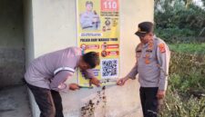 Kapolsek Buay Madang Timur, Iptu Swisspo, mendampingi anggotanya memasang spanduk sosialisasi layanan kepolisian dan larangan membakar hutan di Desa Teko Rejo, Kecamatan Buay Madang Timur, Kabupaten OKU Timur. 