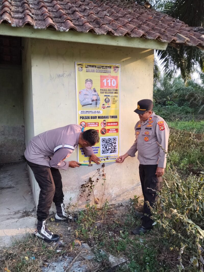Kapolsek Buay Madang Timur, Iptu Swisspo, mendampingi anggotanya memasang spanduk sosialisasi layanan kepolisian dan larangan membakar hutan di Desa Teko Rejo, Kecamatan Buay Madang Timur, Kabupaten OKU Timur. 