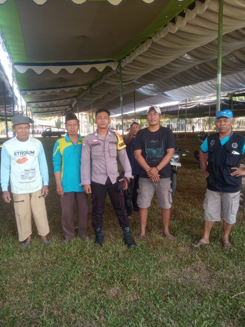 Bhabinkamtibmas Polsek Buay Madang Timur, Brigadir Sendi (ketiga dari kiri), berfoto bersama panitia dan warga saat mengecekan lokasi persiapan Pengajian Akbar Harlah Jatman NU di lapangan Desa Sumber Mulyo, Kabupaten OKU Timur. 