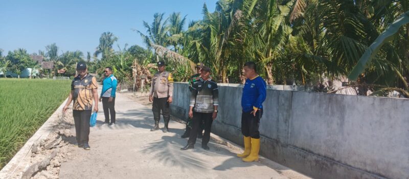 Bhabinkamtibmas Polsek Buay Madang Timur bersama Camat, Babinsa, Kepala Desa, dan pendamping kecamatan meninjau fisik hasil pembangunan Tembok Penahan Tanah (TPT) di Desa Metro Rejo, Kabupaten OKU Timur. 