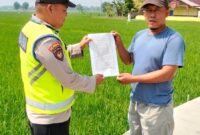 Personel Polsek Buay Madang Timur menyerahkan lembaran Maklumat Kapolda Sumsel tentang larangan membakar hutan dan lahan kepada seorang warga di area persawahan Desa Kedu, Kecamatan Buay Madang Timur, Kabupaten OKU Timur. 