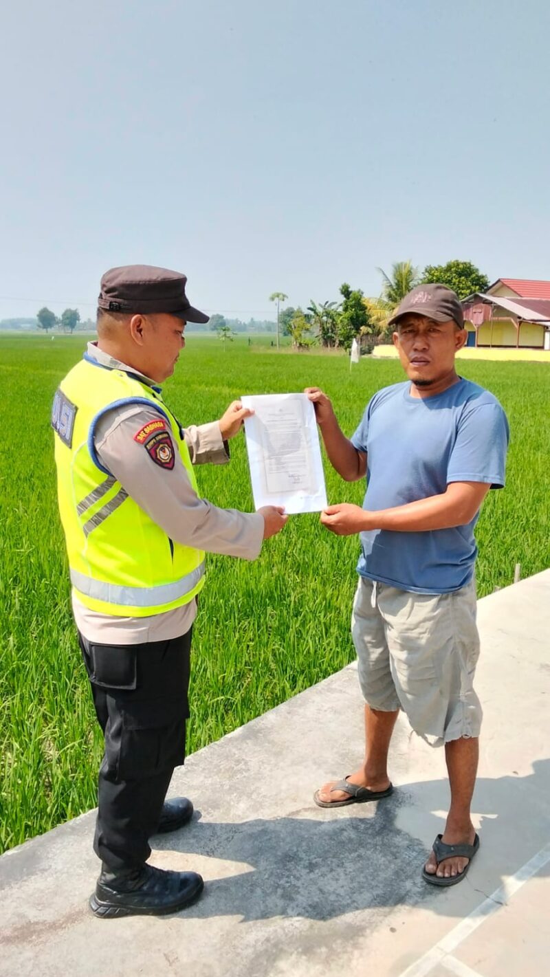 Personel Polsek Buay Madang Timur menyerahkan lembaran Maklumat Kapolda Sumsel tentang larangan membakar hutan dan lahan kepada seorang warga di area persawahan Desa Kedu, Kecamatan Buay Madang Timur, Kabupaten OKU Timur. 