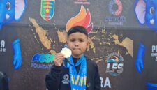 Atlet renang muda asal OKU Timur, Zakra Alkahfi Karim (Alfy), menunjukkan medali yang diraihnya pada Kejuaraan Renang Piala Kemenpora RI 2026 di Kolam Renang Pahoman, Bandar Lampung. 