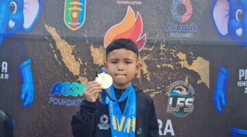 Atlet renang muda asal OKU Timur, Zakra Alkahfi Karim (Alfy), menunjukkan medali yang diraihnya pada Kejuaraan Renang Piala Kemenpora RI 2026 di Kolam Renang Pahoman, Bandar Lampung. 