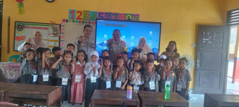 Personel Polsek Buay Madang Timur, Ps Kanit Binmas Bripka Ari Wicaksono dan Bhabinkamtibmas Bripka Nur Holik, berfoto bersama dewan guru dan siswa-siswi kelas 1 SDN 2 Rejodadi saat kegiatan penyuluhan tertib lalu lintas, anti-bullying, dan kedisiplinan di Desa Rejodadi, Kecamatan Buay Madang Timur. 