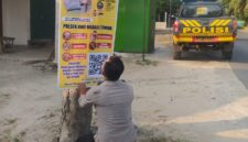 Personel Polsek Buay Madang Timur memasang banner Layanan Kepolisian 110 dan imbauan larangan karhutla di tepi jalan Desa Tanjung Mulya, Kecamatan Buay Madang Timur, OKU Timur. 