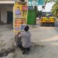 Personel Polsek Buay Madang Timur memasang banner Layanan Kepolisian 110 dan imbauan larangan karhutla di tepi jalan Desa Tanjung Mulya, Kecamatan Buay Madang Timur, OKU Timur. 
