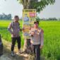 Kapolsek Buay Madang Timur Iptu Swisspo (kanan) bersama Bripka Didi Handoko memasang spanduk Layanan Kepolisian 110 dan imbauan larangan kebakaran hutan dan lahan (Karhutla) di Desa Wonodadi Asri, Kecamatan Buay Madang Timur, Kabupaten OKU Timur. 