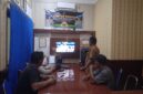 Anggota Polsek Buay Madang Timur bersama masyarakat pencinta sepak bola menyaksikan pertandingan Pesta Bola Dunia 2026 antara Inggris vs Argentina di Mako Polsek Buay Madang Timur, Kabupaten OKU Timur. 