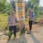 Kapolsek Buay Madang Timur Iptu Swisspo (kiri) bersama personel memperlihatkan spanduk Layanan Kepolisian 110 dan imbauan larangan Karhutla yang dipasang di Desa Sukoharjo, Kecamatan Buay Madang Timur, Kabupaten OKU Timur. 