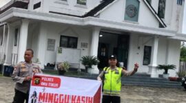 Personel Polsek Buay Madang Timur, Aiptu Mulyono dan Bripka Iswanto, membentangkan spanduk program 