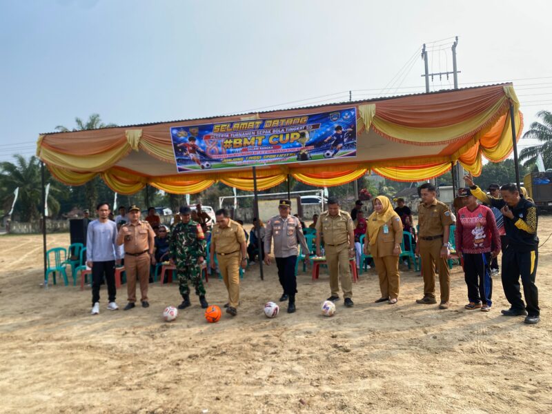 Kadindikbud OKU Timur Wakimin, bersama Camat Buay Madang Timur Ramadhan Agusten, Kapolsek Buay Madang Timur Iptu Swisspo, Danramil, serta jajaran terkait melakukan tendangan bola pertama sebagai tanda dibukanya Turnamen Sepak Bola Tingkat SD #BMT CUP 2026 di Lapangan Desa Karang Tengah, OKU Timur. 