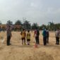 Personel Polsek BMT melakukan pengamanan melekat di tengah Lapangan Desa Karang Tengah saat berlangsungnya hari kedua Turnamen Sepak Bola Tingkat SD #BMT Cup 2026 di Kabupaten OKU Timur. 