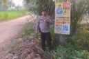 Kapolsek Buay Madang Timur Iptu Swisspo, menunjukkan spanduk Layanan Kepolisian 110 yang dipasang di kawasan Desa Sumedang Sari, Kecamatan Buay Madang Timur, Kabupaten OKU Timur. 