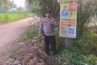 Kapolsek Buay Madang Timur Iptu Swisspo, menunjukkan spanduk Layanan Kepolisian 110 yang dipasang di kawasan Desa Sumedang Sari, Kecamatan Buay Madang Timur, Kabupaten OKU Timur. 