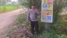 Kapolsek Buay Madang Timur Iptu Swisspo, menunjukkan spanduk Layanan Kepolisian 110 yang dipasang di kawasan Desa Sumedang Sari, Kecamatan Buay Madang Timur, Kabupaten OKU Timur. 