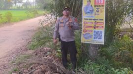 Kapolsek Buay Madang Timur Iptu Swisspo, menunjukkan spanduk Layanan Kepolisian 110 yang dipasang di kawasan Desa Sumedang Sari, Kecamatan Buay Madang Timur, Kabupaten OKU Timur. 