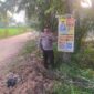 Kapolsek Buay Madang Timur Iptu Swisspo, menunjukkan spanduk Layanan Kepolisian 110 yang dipasang di kawasan Desa Sumedang Sari, Kecamatan Buay Madang Timur, Kabupaten OKU Timur. 