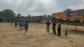 Personel Polsek Buay Madang Timur memantau situasi lapangan saat mendampingi pelaksanaan hari ketiga Turnamen Sepak Bola Anak SD #BMT Cup 2026 di Desa Karang Tengah, OKU Timur. 