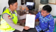Personel Polsek Buay Madang Timur menyerahkan lembaran Maklumat Karhutla kepada warga di Desa Sumber Harjo, Kecamatan Buay Madang Timur, OKU Timur.