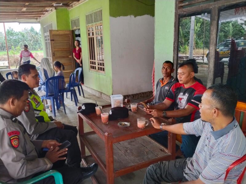 Personel Polsek Buay Madang Timur, Aipda Sahrul Munir dan Aipda Zulkifli, berdialog santai bersama warga saat melaksanakan giat sambang Kamtibmas di sebuah rumah di Desa Sumber Mulyo, Kecamatan Buay Madang Timur, Kabupaten OKU Timur. 