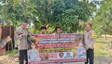 Personel Polsek Buay Madang Timur, Polres OKU Timur, membentangkan spanduk himbauan