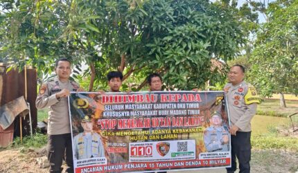 Personel Polsek Buay Madang Timur, Polres OKU Timur, membentangkan spanduk himbauan "Stop Membakar Hutan dan Lahan" bersama warga di Kecamatan Buay Madang Timur, OKU Timur, Sumatera Selatan.