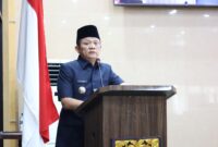 Bupati OKU Timur Lanosin, menyampaikan jawaban pemerintah terhadap pemandangan umum fraksi-fraksi DPRD atas Raperda Pertanggungjawaban Pelaksanaan APBD TA 2025 di Ruang Rapat Paripurna DPRD OKU Timur. 