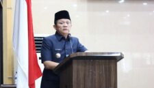 Bupati OKU Timur Lanosin, menyampaikan jawaban pemerintah terhadap pemandangan umum fraksi-fraksi DPRD atas Raperda Pertanggungjawaban Pelaksanaan APBD TA 2025 di Ruang Rapat Paripurna DPRD OKU Timur. 