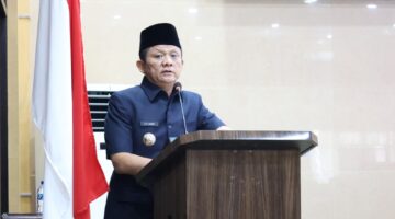 Bupati OKU Timur Lanosin, menyampaikan jawaban pemerintah terhadap pemandangan umum fraksi-fraksi DPRD atas Raperda Pertanggungjawaban Pelaksanaan APBD TA 2025 di Ruang Rapat Paripurna DPRD OKU Timur. 