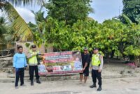 Personel Polsek Buay Madang Timur bersama warga membentangkan spanduk imbauan "Stop Membakar Hutan dan Lahan" saat menggelar sosialisasi mitigasi Karhutla di Kecamatan Buay Madang Timur, Kabupaten OKU Timur. 