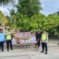 Personel Polsek Buay Madang Timur bersama warga membentangkan spanduk imbauan 