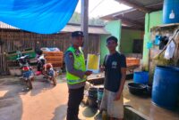 Anggota Polsek Buay Madang Timur, Bripka Iswanto, menyerahkan lembaran Maklumat Kapolda Sumsel tentang larangan membakar hutan dan lahan secara langsung kepada salah seorang warga di Desa Kumpul Rejo, Kecamatan Buay Madang Timur, Kabupaten OKU Timur. 