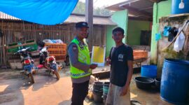 Anggota Polsek Buay Madang Timur, Bripka Iswanto, menyerahkan lembaran Maklumat Kapolda Sumsel tentang larangan membakar hutan dan lahan secara langsung kepada salah seorang warga di Desa Kumpul Rejo, Kecamatan Buay Madang Timur, Kabupaten OKU Timur. 