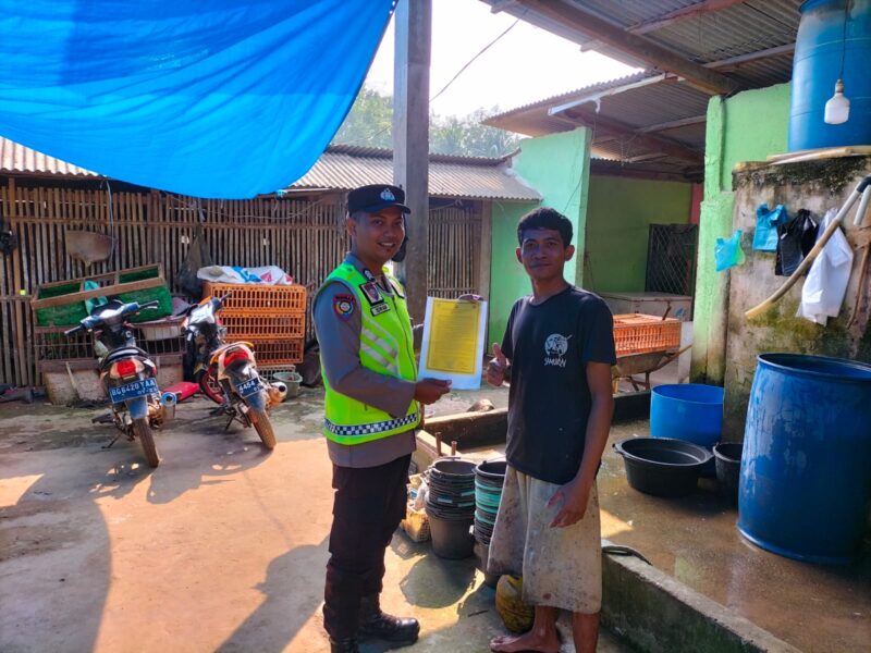 Anggota Polsek Buay Madang Timur, Bripka Iswanto, menyerahkan lembaran Maklumat Kapolda Sumsel tentang larangan membakar hutan dan lahan secara langsung kepada salah seorang warga di Desa Kumpul Rejo, Kecamatan Buay Madang Timur, Kabupaten OKU Timur. 